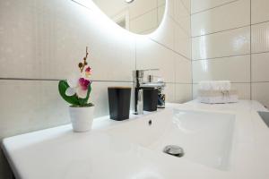 a bathroom with a white sink with a flower on it at Oasis White in Durrës