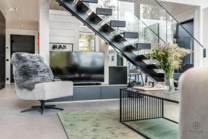 a living room with a television and a chair at Villa Ailo in Kittilä