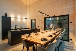 a long dining room with a long table and chairs at Villa Ailo in Kittilä