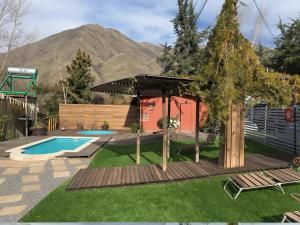 a backyard with a pool and a deck with a umbrella at Oceana Suites Refugio de Maipo in San José de Maipo