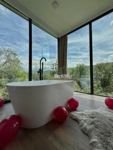 a bath tub in a room with large windows at Nest House in Dubova +65 photos