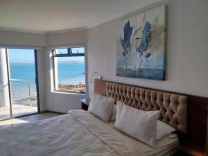a bedroom with a bed with a view of the ocean at Sunset Villa in Langebaan