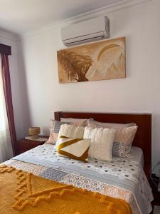 a bedroom with a bed with pillows and a painting at Ponta do Sol Villa in Ponta do Sol