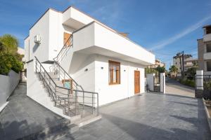 a white house with stairs on a street at Oasis White in Durrës