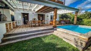 a deck with a swimming pool and a house at Riverside Cottage in Stanford