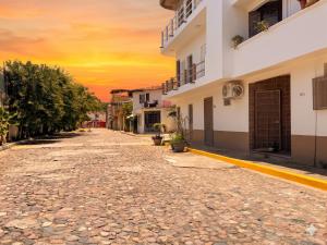 an empty street in a city at sunset at Polly's Home Boutique GuestHouse & Private Suites in Aralias in Puerto Vallarta