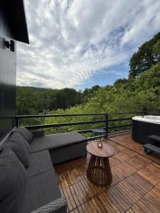 a couch and a table on a deck with a view at Nest House in Dubova