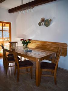 a wooden table with chairs and a vase of flowers on it at Ferienwohnung Dürnberger in Liebenfels