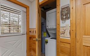 a door to a kitchen with a stove and a refrigerator at Bearadise Hot Tub 6 Min to The Island in Pigeon Forge +21 photos