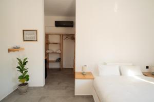 a bedroom with a white bed and a plant at Lavender Suite in Paránimfoi +22 photos