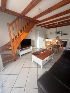 a living room with a couch and a table at Maison près de la mer in Yffiniac