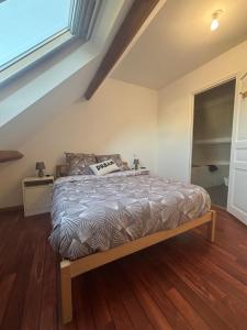 a bedroom with a bed with a wooden floor at Maison près de la mer in Yffiniac