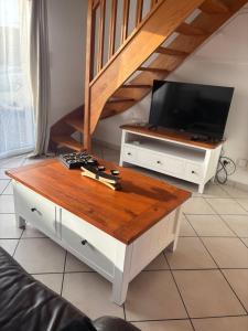a living room with a tv and a coffee table at Maison près de la mer in Yffiniac