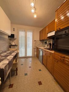 a kitchen with wooden cabinets and a large microwave at Appartement Montalieu in Montalieu-Vercieu