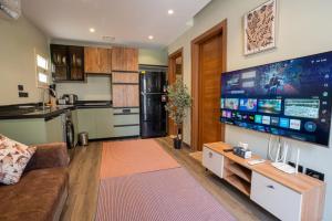 a living room with a couch and a large flat screen tv at Cozy Studio Apartment in Sheikh Zayed in Sheikh Zayed