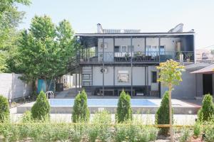 a house with a swimming pool in front of it at Apricot Lodge in Bishkek