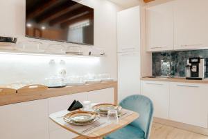 a kitchen with white cabinets and a table and chairs at Domo De Uccio in Alghero +42 photos