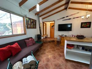 a living room with a couch and a tv at Oceana Suites Refugio de Maipo in San José de Maipo
