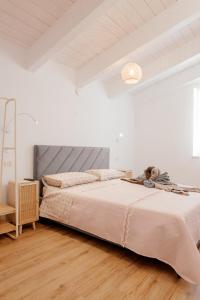 a bedroom with a large bed in a white room at Domo De Uccio in Alghero