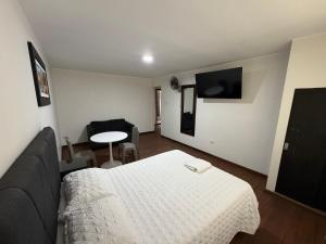 ein Zimmer mit einem Bett, einer Couch und einem Tisch in der Unterkunft Hostal Anthony's in Lima