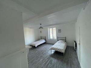 an empty room with two beds and a window at Appartement 2 in Vireux-Wallerand