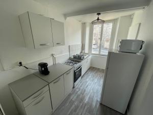 a kitchen with white cabinets and a refrigerator at Appartement 2 in Vireux-Wallerand