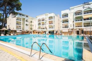 a large swimming pool in front of some buildings at Joni's Twin Condos (Pool&Pine View) in Golem