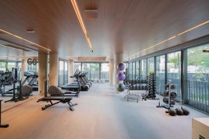 a gym with treadmills and exercise equipment and windows at GO24 by LikeHome in Auxiliadora