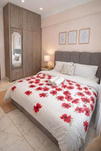 a bedroom with a large bed with red flowers on it at The Legend Place in Eldoret