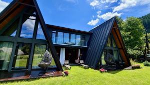 a house with a black roof and windows at Zago Alpin in Câmpulung Moldovenesc