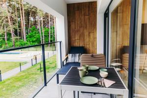 ein Esszimmer mit Tisch und Balkon in der Unterkunft Morze Słońca in Łukęcin