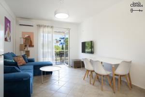 a living room with a blue couch and a table and chairs at Joni's Twin Condos (Pool&Pine View) in Golem