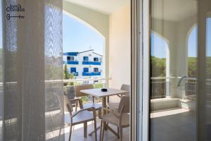 a balcony with a table and chairs and a window at Joni's Twin Condos (Pool&Pine View) in Golem