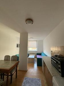 a kitchen and living room with a table and a couch at Apartment Lamele Bugojno in Bugojno