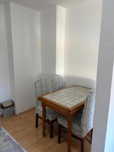 a dining room table with two chairs and a table at Apartment Lamele Bugojno in Bugojno