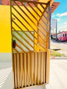 a wooden gate on the side of a yellow building at Pousada e Hostel das Rosas in Barreirinhas
