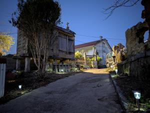 a house with lights on the side of a road at Sálvora, Illas da Pousa in Ribeira