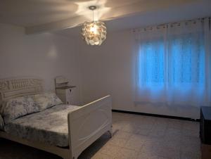 a bedroom with a bed and a chandelier at Sálvora, Illas da Pousa in Ribeira