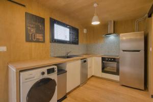 a kitchen with a stainless steel refrigerator and a sink at Studio bois Le Colibri à Chambley in Hagéville