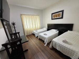 ein Hotelzimmer mit zwei Betten und einem Fenster in der Unterkunft Hostal Anthony's in Lima