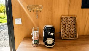 a coffeemaker and cups sitting on a counter at Studio bois Le Colibri à Chambley in Hagéville +39 photos