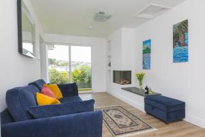 a living room with a blue couch and a fireplace at Ocean Parc in Carbis Bay