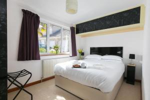 a bedroom with a large white bed and a window at Ocean Parc in Carbis Bay