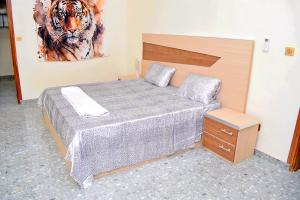 a bedroom with a bed and a painting of a tiger at Residence LaFina in Saly Portudal