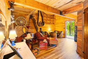 a living room in a log cabin with wooden walls at Nolichuckey Bluffs Bed & Breakfast Cabins in Greeneville
