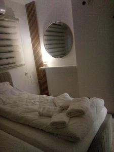 an unmade bed in a bedroom with a mirror at Be Netivei BE NETIVOTI in Netivot