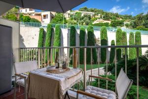 a balcony with a table and chairs and a fence at La Plage - Studio - Face à la Mer - Clim Terrasse in Menton
