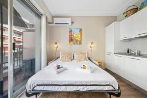 a bedroom with a bed with two trays on it at La Plage - Studio - Face à la Mer - Clim Terrasse in Menton