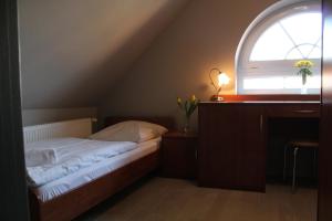 a bedroom with a bed with a window and a desk at Dworek Mitro in Gdynia