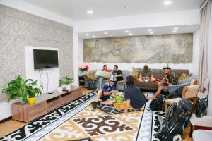 a group of people sitting in a living room at Apricot Lodge in Bishkek